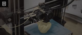A imagem mostra uma impressora 3D durante o processo de impressão de um objeto.